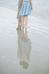 Couple stand and walk on the beach. 