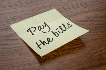 Sticky note with the text Pay the bills