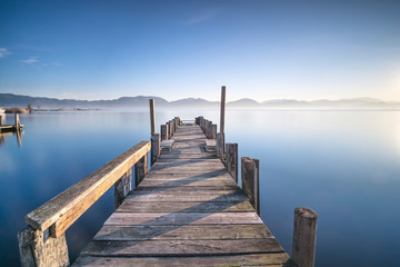 Fototapeta premium Wooden pier or jetty and lake at sunrise. Torre del lago Puccini Versilia Tuscany, Italy