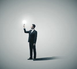 Businessman holding glowing lamp