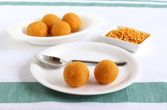 Laddu, a traditional, popular, and delicious Indian sweet, on a plate and tray.
