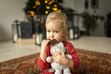 little girl .with a toy near christmas tree