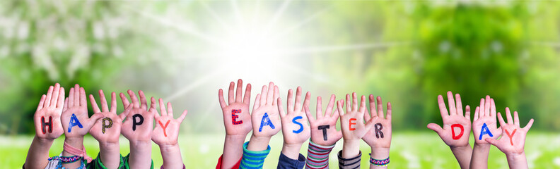 Children Hands Building Colorful Word Happy Easter Day. Green Grass Meadow As Background
