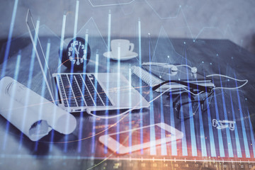 Stock market graph on background with desk and personal computer. Double exposure. Concept of financial analysis.