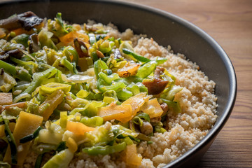 Moroccan couscous with vegetables in a wooden table