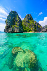 Tropical Shimizu Island and paradise beach, El Nido, Palawan, Philippines. Tour A Route. Coral reef and sharp limestone cliffs.