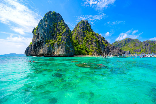 Tropical Shimizu Island and paradise beach, El Nido, Palawan, Philippines. Tour A Route. Coral reef and sharp limestone cliffs.