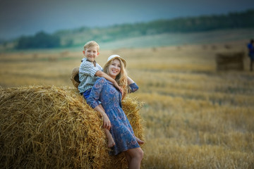Fototapeta na wymiar Mom and son close up in a field with mowed wheat.