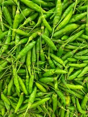 fresh ripe green hot chili close up in market. healthy food texture. vegetables background.