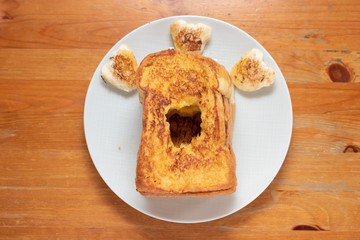 Toast on a white plate on a wooden table.