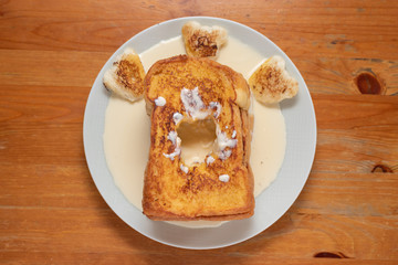 Toast on a white plate on a wooden table.