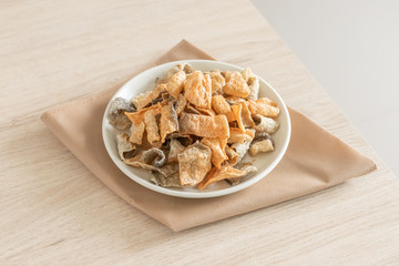 Crispy fried salmon skin on wooden table background.