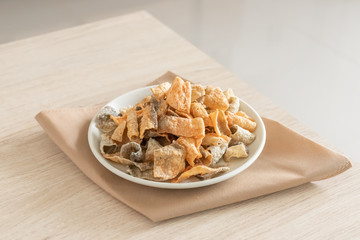 Crispy fried salmon skin on wooden table background.