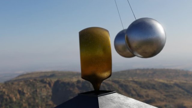 spheres swinging through a rotating gold ring on top of a pyramid in mountain landscape, seamless animation with geometric shapes objects, 4k loop