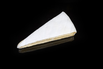 Top view of piece of brie cheese on black background