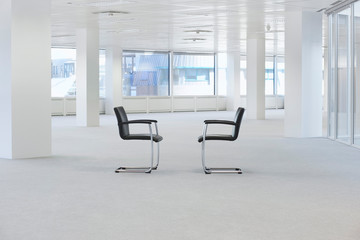 Two facing chairs in empty office space