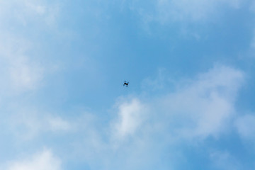 quadrocopter in the blue sky with clouds
