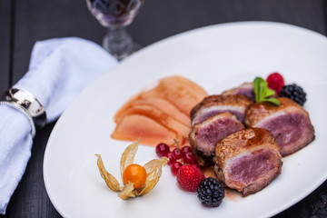 pink duck breast with berry sauce, physalis and pear