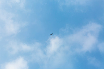Naklejka na ściany i meble quadrocopter in the blue sky with clouds