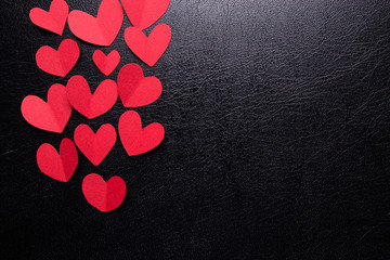 A lot of small hearts of red color against on a black background. Happy Valentine's Day.