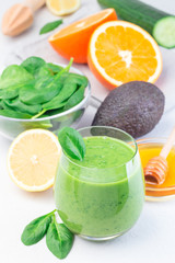 Green detox smoothie with avocado, spinach, cucumber, orange, lemon and honey, vertical