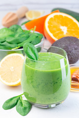 Green detox smoothie with avocado, spinach, cucumber, orange, lemon and honey,  vertical
