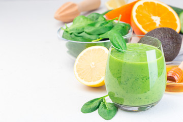 Green detox smoothie with avocado, spinach, cucumber, orange, lemon and honey, horizontal, copy space