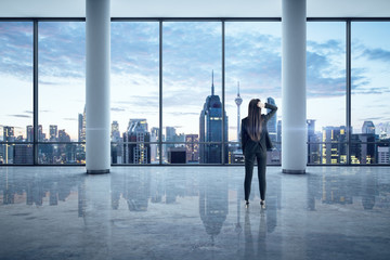 Fototapeta premium Businesswoman standing in empty office interior