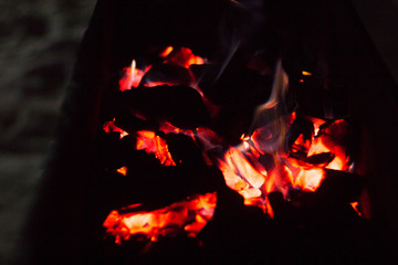 Red-hot coals and fire on them. Coals in the grill with flying lights.