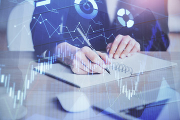 Forex graph on hand taking notes background. Concept of research. Multi exposure