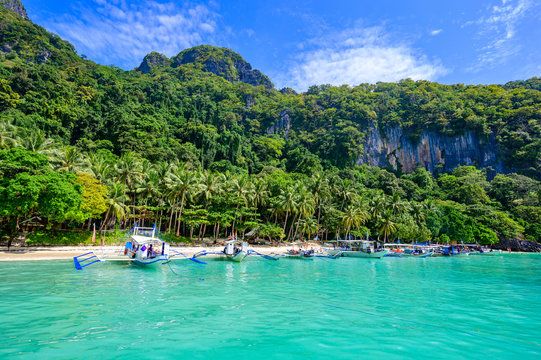 Tropical Papaya beach at paradise coast, El Nido, Palawan, Philippines. Tour A Route. Coral reef and sharp limestone cliffs.