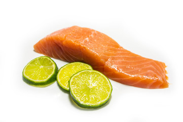 A piece of salted salmon with greens closeup. Red fish on a white background