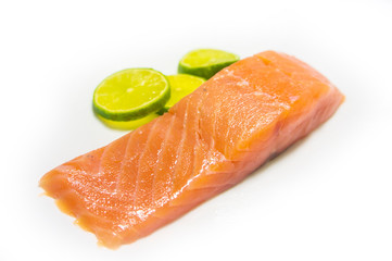 A piece of salted salmon with greens closeup. Red fish on a white background