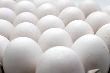 An isolated tray of eggs from recycled materials with white eggs on a white background. Selective Focus