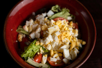 Green chopped eggs salad with lettuce, tomato, summer dish.
