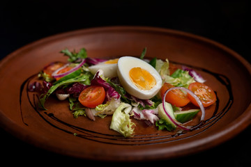 Half of boiled egg with vegetables, tomatoes, salad, onion cucumbers.