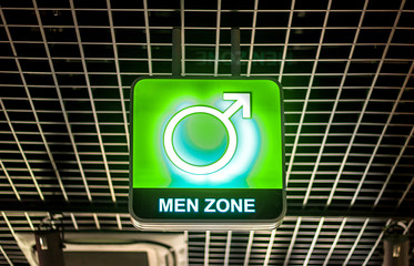 The concept of gender inequality, a male gender symbol on a luminous neon sign with the words 