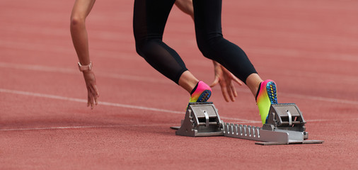 Athlete female feet on starting block ready for a sprint start	