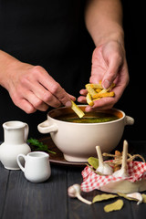 green soup, chicken broth with spinach on a dark wooden background