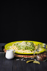pasta with cheese cream sauce and spinach on a dark wooden background