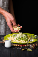pasta with cheese cream sauce and spinach on a dark wooden background