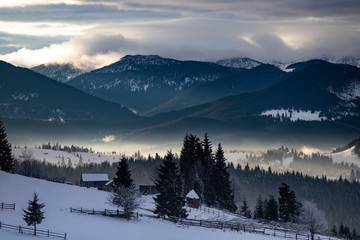 Fototapeta na wymiar Winter forest in dramatic sunrise in the Carpathians, Romania.