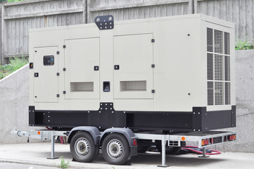 Industrial generator power. Mobile diesel backup generator on caravan wheels.  Backup power supply generator for emergency. - obrazy, fototapety, plakaty