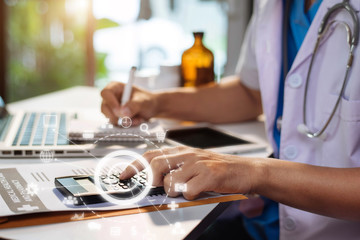 Male medicine doctor, physician or practitioner in lab room writing on blank notebook and work on laptop computer with medical stethoscope on the desk at hospital. Medic tech concept.