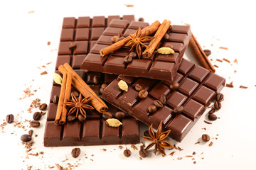 chocolate bar pieces and spices isolated on white background