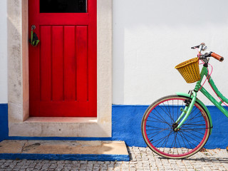 Bicicleta junto a puerta roja en Portugal