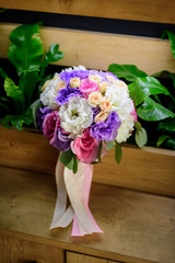 Wedding bouquet from roses and colorful flowers.