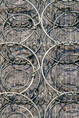 Texture of springs of a broken mattress, gray background of a disassembled sofa close-up