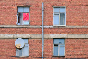 The Soviet flag is hung on an old red brick building USSR