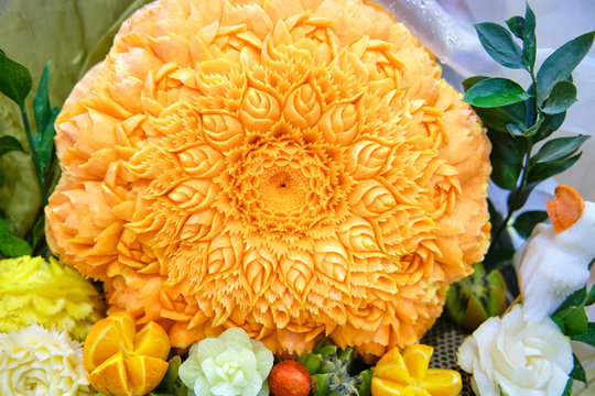 Pumpkin, oranges and mango with carved patterns in the form of a flower. The art of carving on food